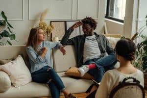 Group therapy session with a counselor and diverse clients in a cozy office.