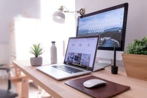 Modern home office workspace with laptop, monitor, and accessories for remote work.