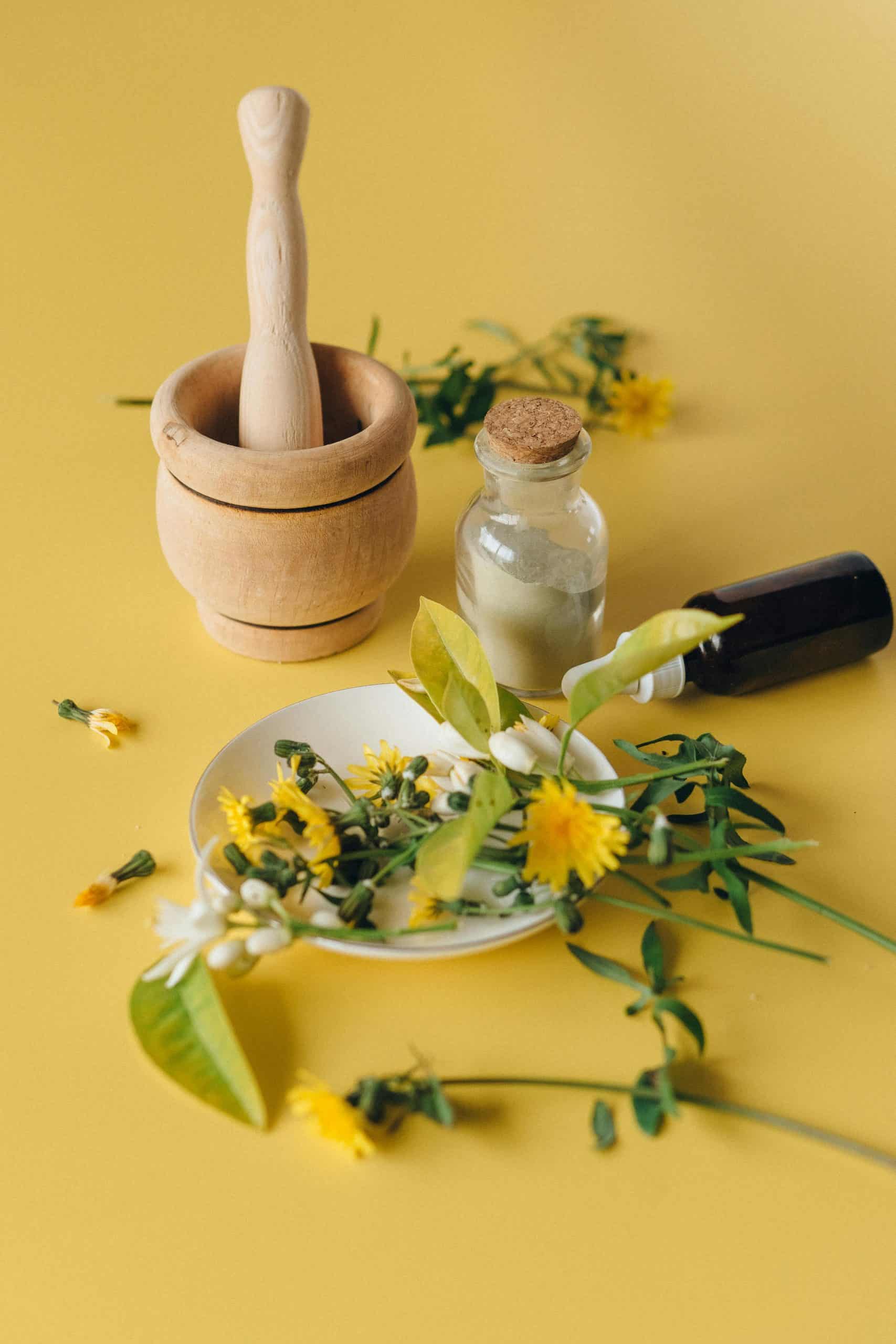 Traditional herbal medicine and acupuncture tools on yellow background.